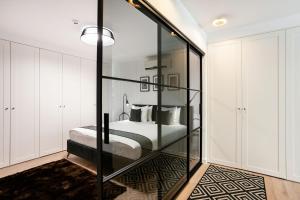 维尔纽斯Luxury for everyone - Hills Park Lux Apartments 2的一间卧室设有一张床和玻璃墙