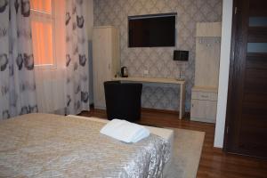亚斯沃Sepia Restauracja & Noclegi的卧室配有一张床,墙上配有电视。