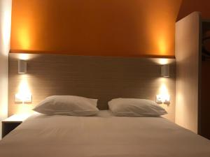 兰斯兰斯西部坦屈厄星辰酒店的一间卧室配有一张带两个白色枕头的大床