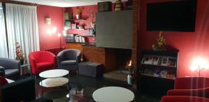 安道尔城七把钥匙酒店的客厅设有红色的墙壁和桌子以及电视。