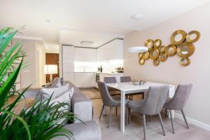 维尔纽斯Luxury for everyone - Hills Park Lux Apartments 1的用餐室以及带桌椅的起居室。