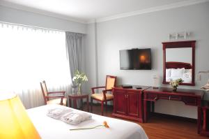 利马Kingdom Hotel的酒店客房带一张床、一张书桌和一面镜子