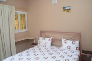 圣路易斯Hotel La Perle的卧室配有带枕头的床铺和窗户。