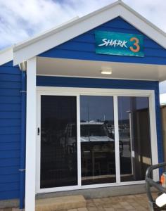 林肯港Port Lincoln Shark Apartment 3的一座蓝色的小建筑,上面有标志