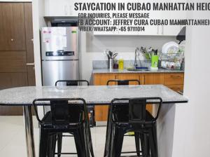 马尼拉5H Tower C Manhattan Heights Cubao QC的厨房配有一张桌子和两张黑色椅子