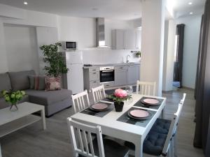 瓦伦西亚New apartment bioparc的厨房以及带白色桌椅的起居室。