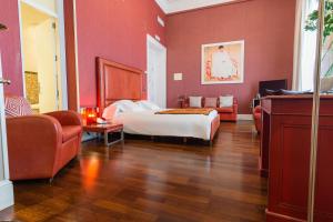 赫雷斯-德拉弗龙特拉加维宫酒店的卧室设有红色的墙壁、一张床和一张沙发