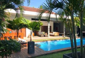 塞米亚克高级别墅水明漾I酒店的棕榈树后院的游泳池