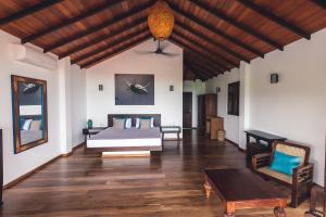 坦加拉OMIA的一间卧室配有一张床,铺有木地板
