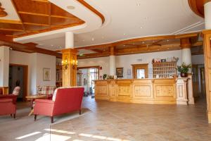 佐尔内丁格拉斯尔兰德酒店的大房间设有木制橱柜和红色椅子