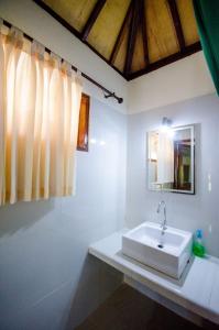 吉利美诺梦幻小屋旅馆的白色的浴室设有水槽和镜子
