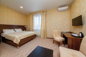 克拉斯诺达尔D Hotel的配有一张床和一张书桌的酒店客房
