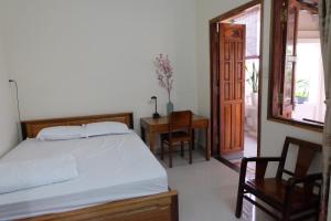 芽庄Moon house tropical garden - Valentine的卧室配有1张床、1张桌子和1把椅子