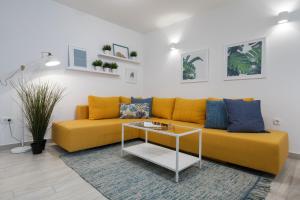 斯普利特Holiday Apartments Split的客厅里一张黄色的沙发,配有桌子