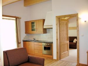 瓦莱迪卡谢斯Hotel Gsieserhof的一个带木制橱柜的厨房和一个沙发