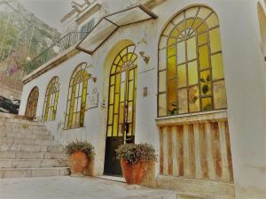 陶尔米纳Villa Mabel的一座古老的建筑,设有彩色玻璃窗和楼梯