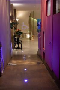 特尔斐尼蒂默斯酒店的走廊上设有紫色的墙壁和鲜花桌