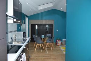 AnsChez Vivi的厨房拥有蓝色的墙壁,配有桌椅