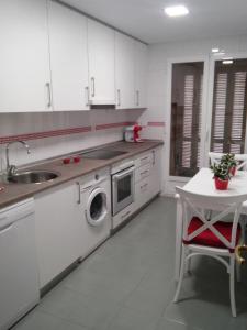 索里亚El Collado 17的白色的厨房配有水槽和洗衣机