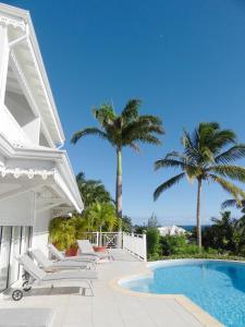 圣弗朗索瓦阿茂多酒店的白色的房子,设有游泳池和棕榈树