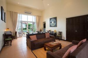 华欣Villa Bougainvillea的客厅配有两张沙发和一张桌子