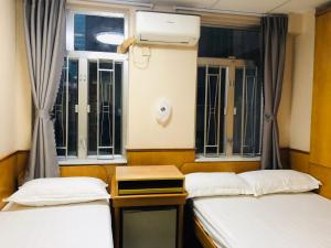 香港祥泰旅馆的带窗户的客房内的两张床