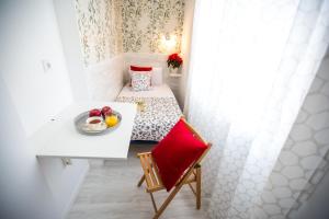 马德里Bloom Inn Madrid的小房间设有一张床和一张桌子,上面放着一盘水果