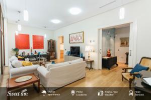 塞维利亚Alameda de Hercules Apartment的客厅配有2张白色沙发和1张桌子