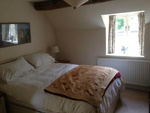奇平卡姆登Brook Cottage的一间卧室设有一张床和一个窗口