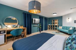 贝尔谢巴מלון לה פינקה - מלון סוויטות יוקרתי的一间卧室设有蓝色的墙壁、一张床和一张书桌