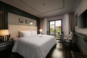 河内La Sinfonía Citadel Hotel and Spa的一间带一张白色大床的卧室和一个阳台