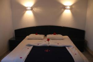 法尤姆New Panorama Resort的一张铺有白色床单和红色鲜花的床