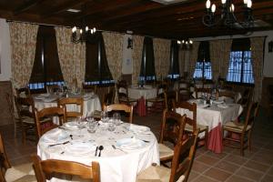 RíogordoHostal Mesón La Era的一间设有白色桌椅和窗户的用餐室