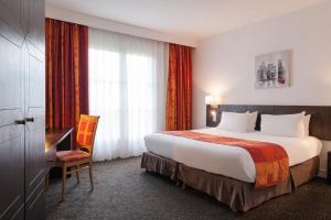 圣马丁杜维维La Berteliere, The Originals Relais (Qualys-Hotel)的酒店客房设有一张大床和一张书桌。