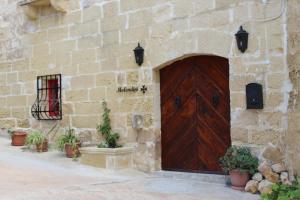 阿尔卜Molendini的一座石头建筑,设有木门和一些植物