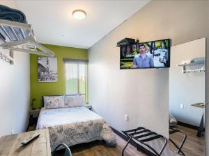 洛杉矶荷洛杉矶 - 圣莫尼卡旅舍的卧室配有一张床,墙上配有电视。