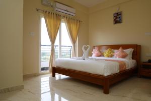 马迪凯里Lali Petals的一间卧室设有一张床和一个大窗户