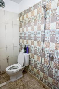 日惹鲁玛班加坦旅馆的一间带卫生间和淋浴的浴室