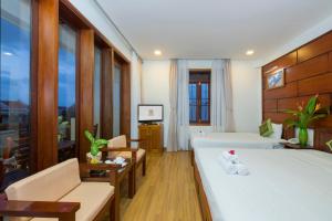 会安Kiman Hoi An Hotel的酒店客房设有床和客厅。