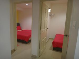 马六甲法摩萨2号民宿的一间卧室配有一张带红色床单和镜子的床