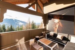 瓦格赖恩Designferienhaus Luxus Bergchalet XXL Ski In-Out Snow Space Wagrain Flachau的带沙发和大窗户的客厅