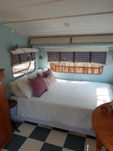奥茨胡恩绿洲香提背包客旅舍的一张大白色的床,位于带桌子的房间