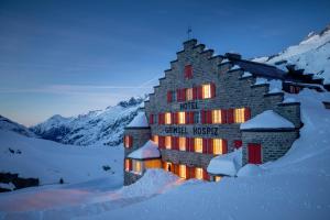 格里姆瑟尔霍斯皮格里姆塞尔霍斯皮斯西斯托西赫斯阿尔卑酒店的雪中建筑物,灯光照亮