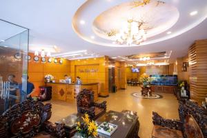 胡志明市Bon Ami Hotel - Thiên Xuân Hotel的大堂设有椅子、桌子和吊灯。