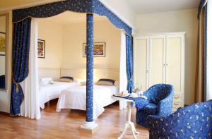 的里雅斯特自由住宿旅馆的一间卧室配有两张带蓝色窗帘的床和椅子