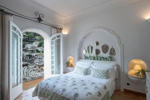 波西塔诺卡萨布奥诺考酒店的卧室配有白色的床和2个大窗户