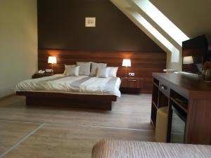 杰尔阿尔法酒店的一间卧室配有一张床和一张带两盏灯的书桌。