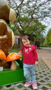 Pinghe元气屋民宿的站在动物雕像旁边的小女孩