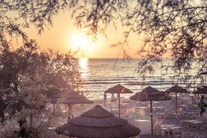 加利波利布拉达海岸大酒店的日落时分带遮阳伞和海洋的海滩