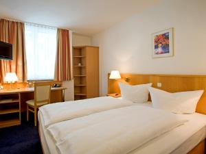 帕绍帕绍苏德IBB酒店的酒店客房设有一张大床和一张书桌。